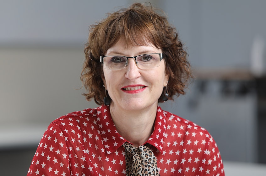 A woman wearing glasses and a red shirt with white stars on it