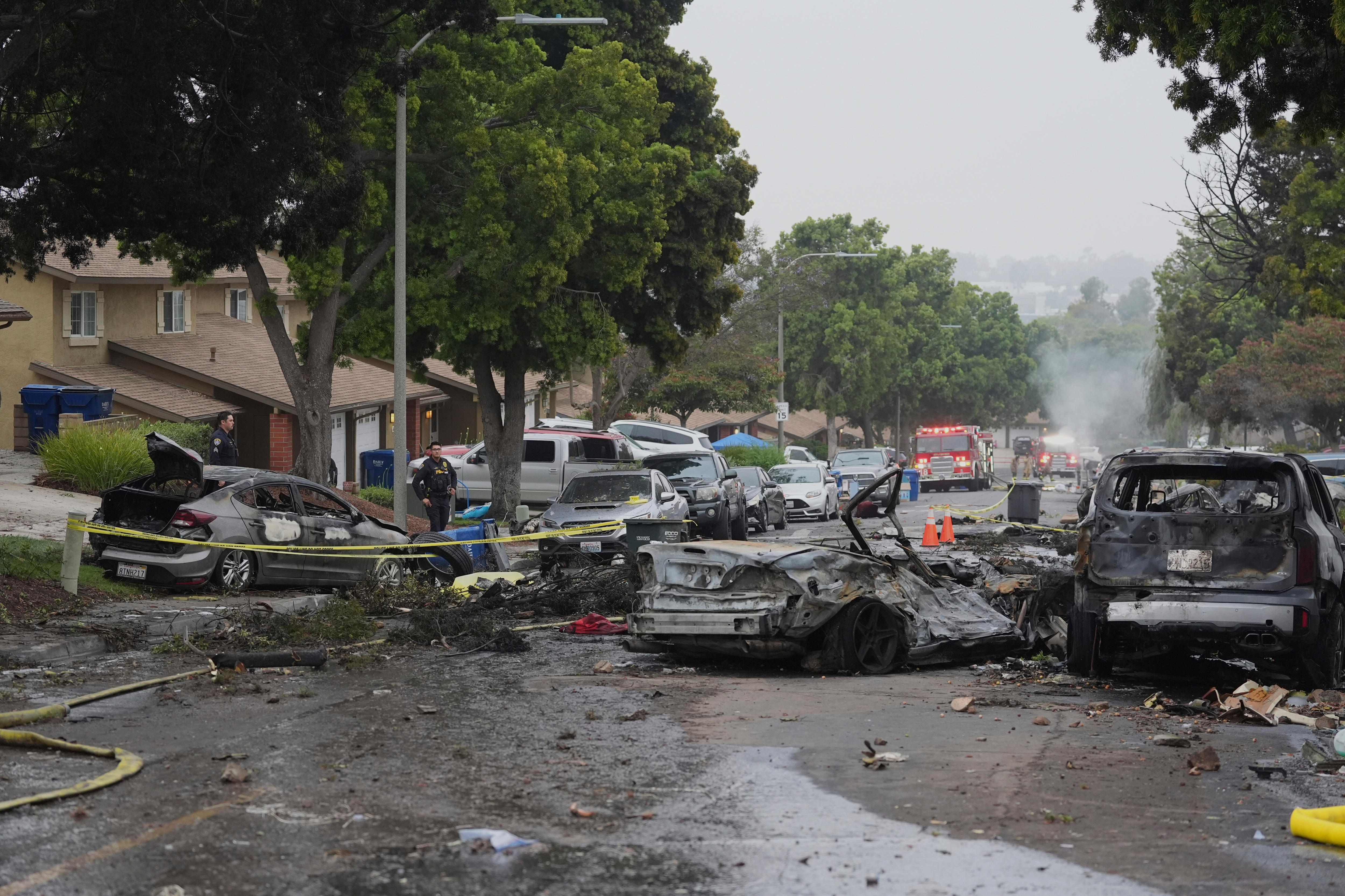 Several cars saw damaged and charred in the middle of a street in the suburbs.