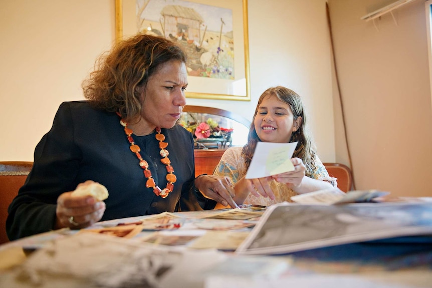 Leanne and Tilly Liddle look at old family photos inside a home.