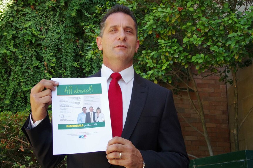 Paul Papalia poses for a picture holding a WA Nationals fundraiser invitation.