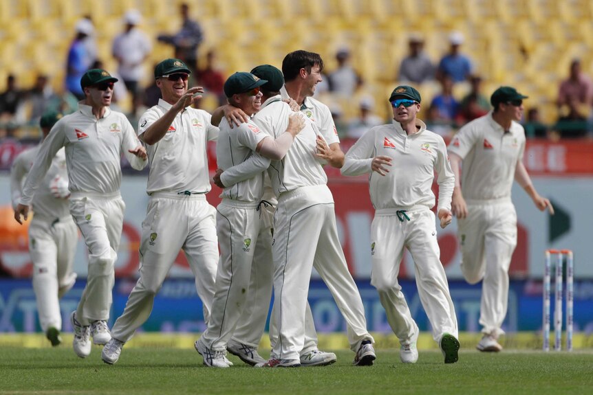 Australia's team celebrates the dismissal of India's Cheteshwar Pujara during the fourth Test in Dharmashala