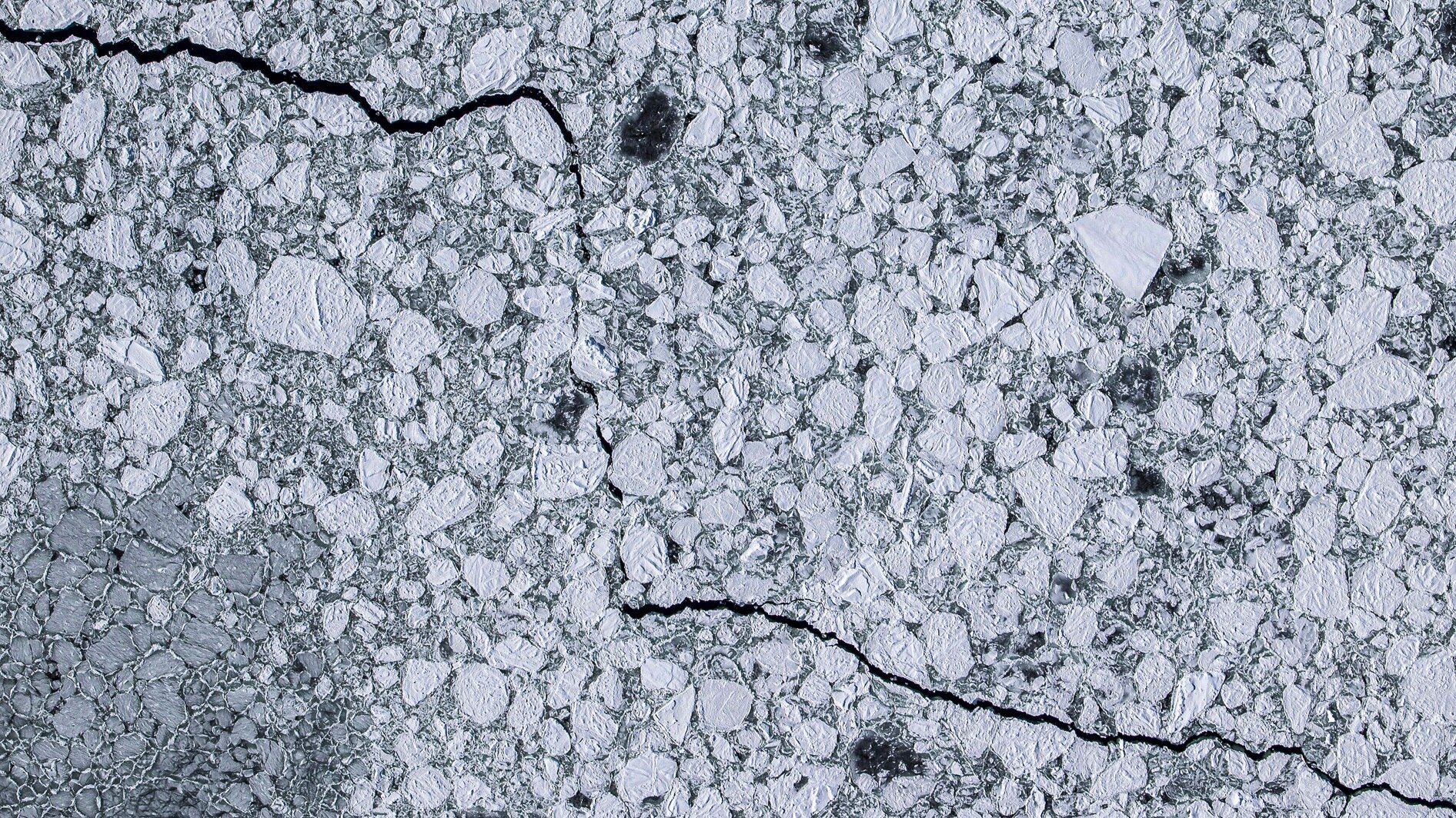 a crack runs between broken ice 