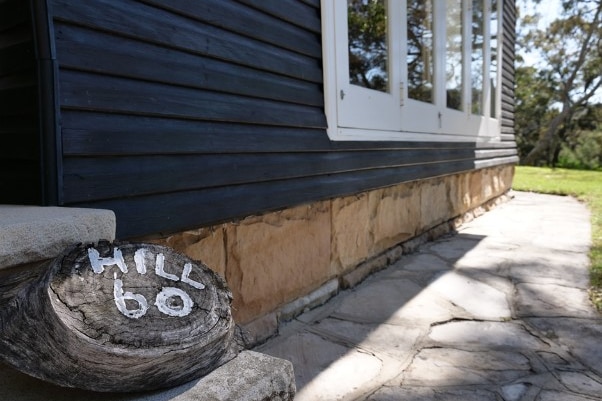 A decent-sized Hill 60 marker lies beside a waterside home