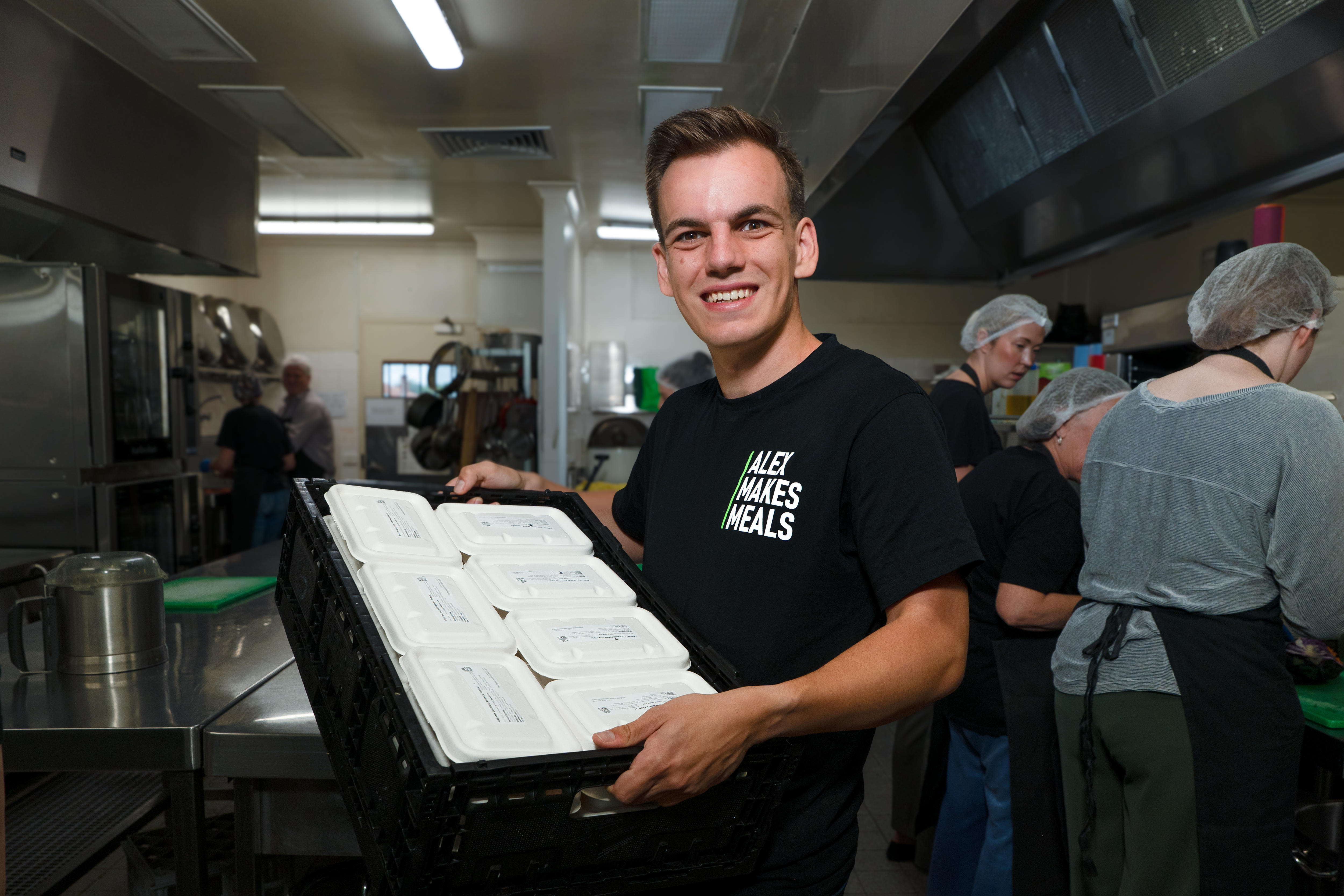 Un hombre sostiene un paquete de comida en la cocina.