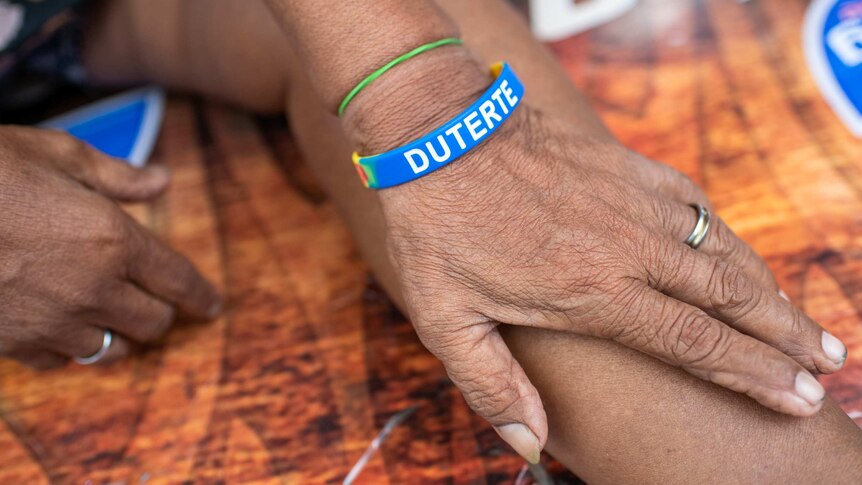 A woman's wrist with a blue plastic wrist-band that reads "Duterte"