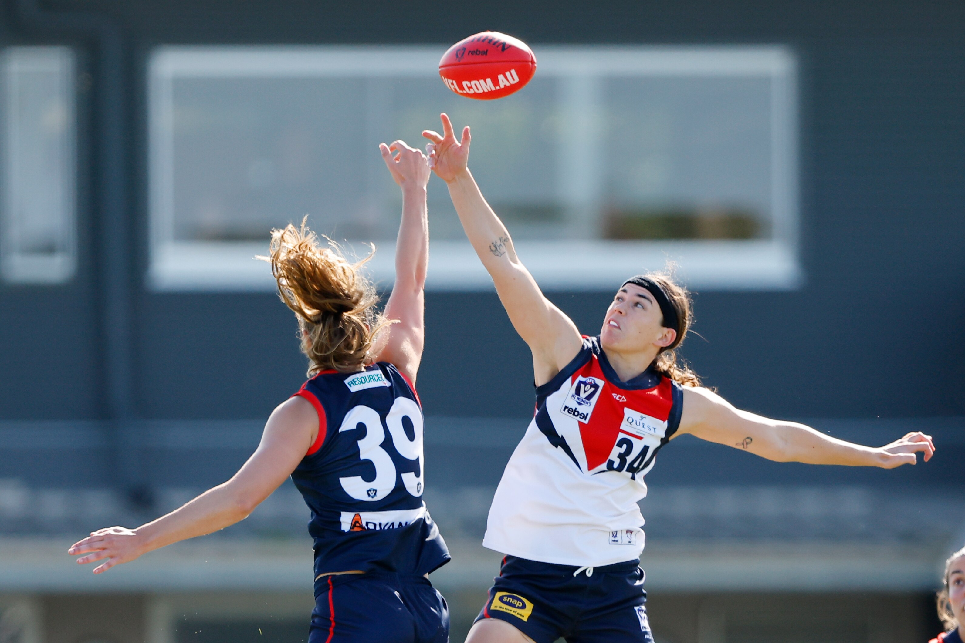 Duas mulheres saltam para a bola em um lance.