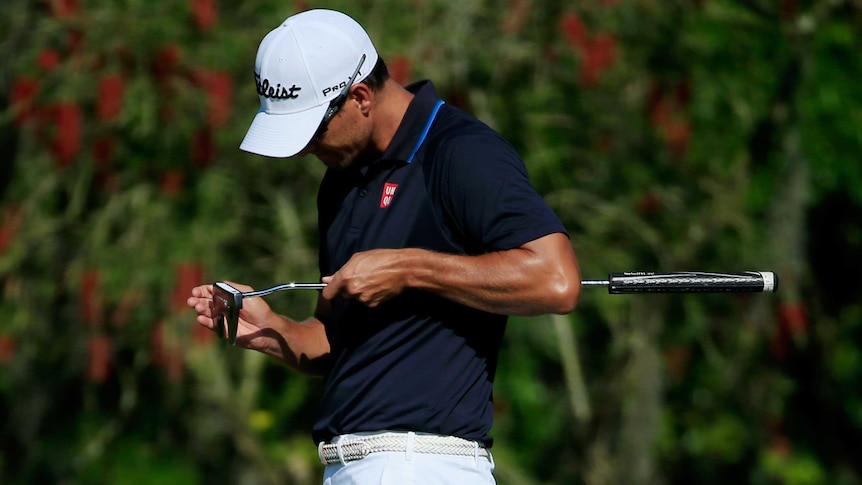 Adam Scott looks at his putter after missing a putt during the Arnold Palmer Invitational.
