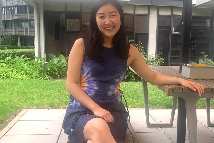 Jessica Ching sitting at a picnic-style table outside. 