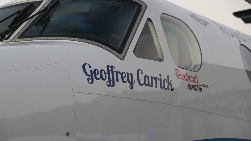 A close-up of an aircraft with name Geoffery Carrick written on the side of it