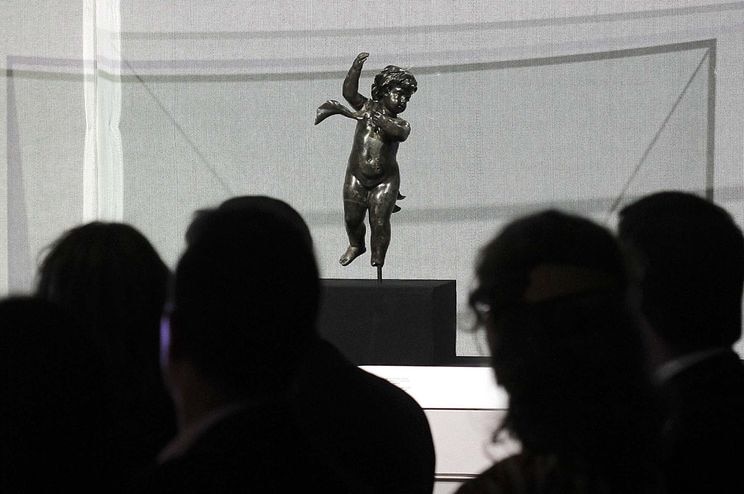 Crowds look at a cherub, one of the bronze statues recovered from the Titanic