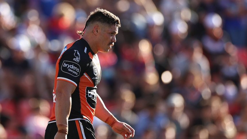 A man looks on during an NRL match