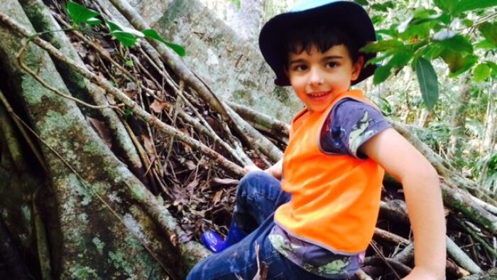 A young boy on a log enjoying a Nature School preschool session at Sea Acres National Park