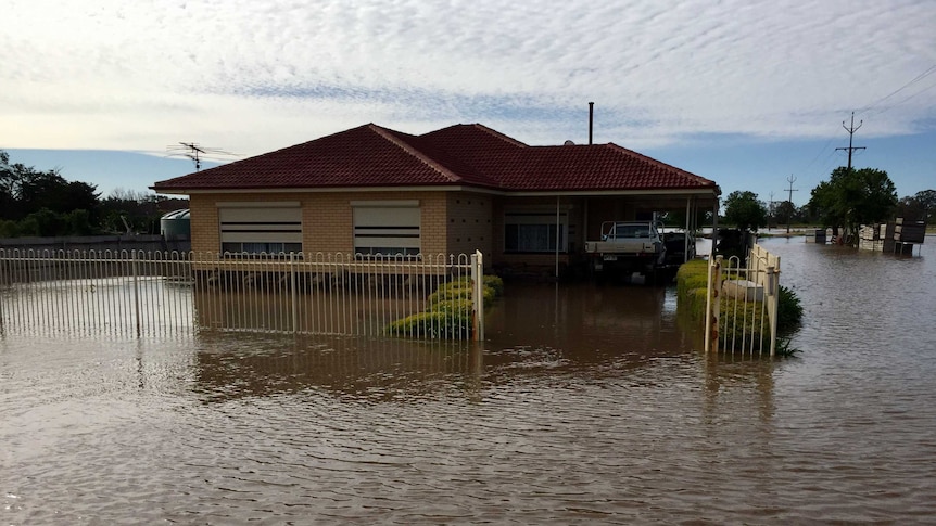 Floodwaters lap at house.