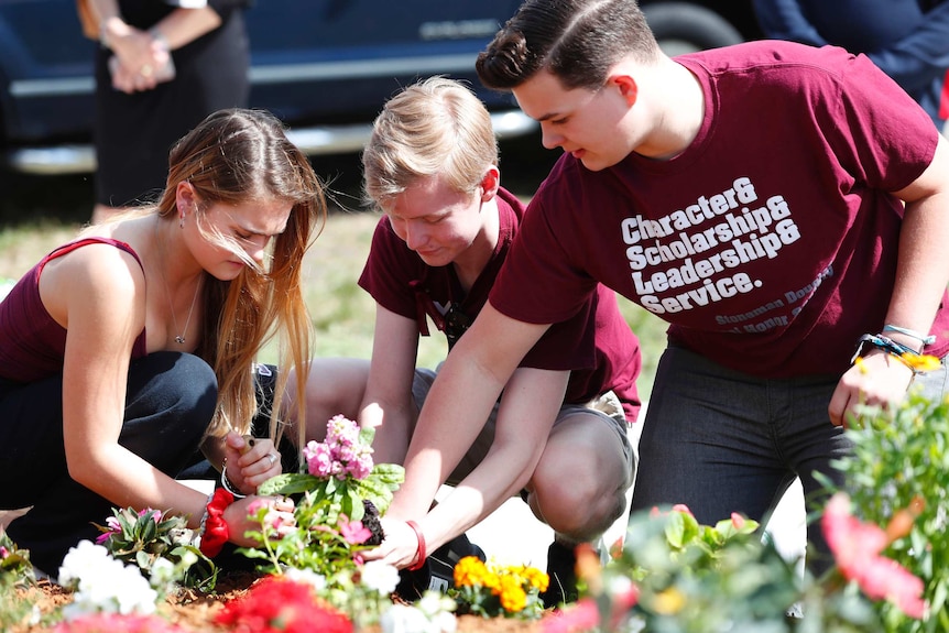 Eve Cohen, Euan Beith and John Barnitt plant flowers outside Marjory Stoneman Douglas High School