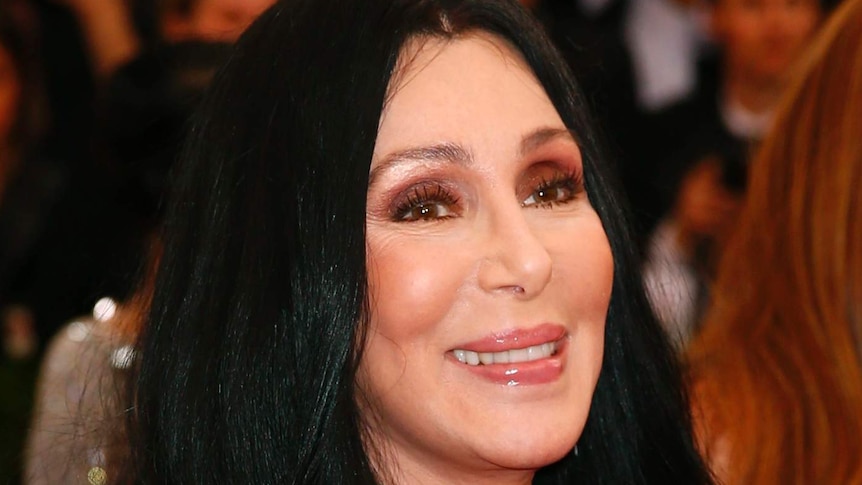 Cher arrives at an event with a big smile on her face.