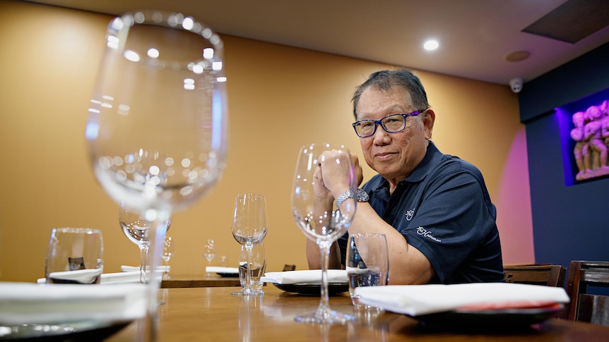 A man sits at a table in a restuarant. 