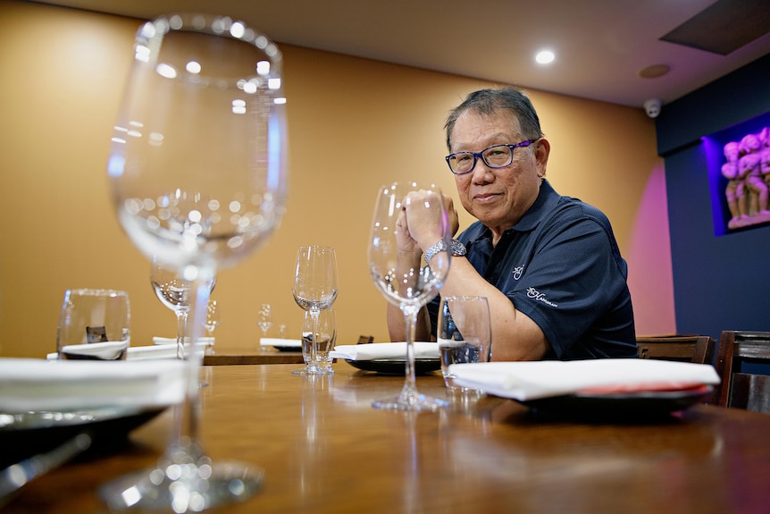 A man sits at a table in a restuarant. 