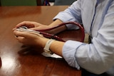 A pair of hands holding a stethoscope