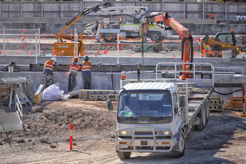 Workers and machinery at the construction site.