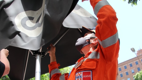 An SES worker secures an umbrella.