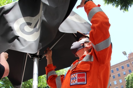 An SES worker secures an umbrella.