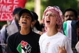 Two children in pro-Palestinian shirts join in with chants at the rally