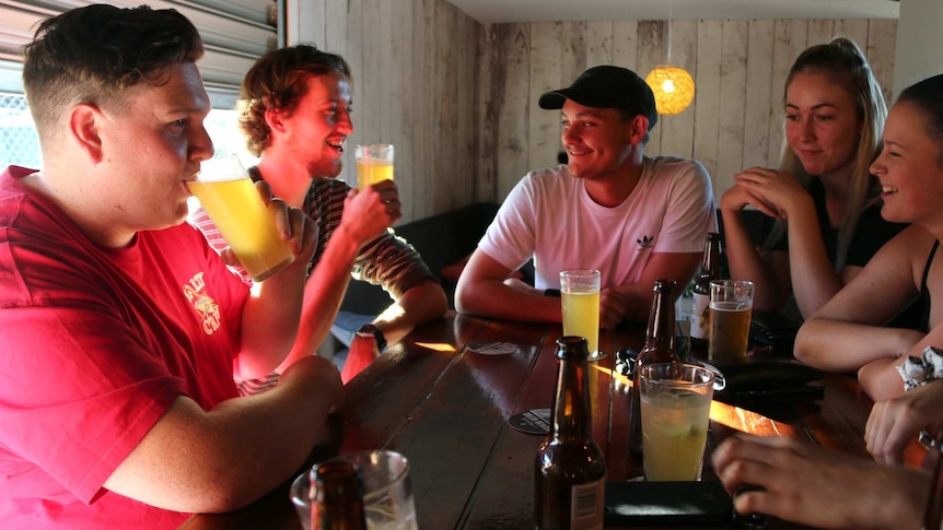 Friends Mitch Verco, Connor Goodall, Joshua Wilson, Jasmine Erskine, and Courtney Flanders chat at a bar.