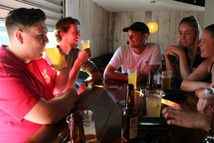 Friends Mitch Verco, Connor Goodall, Joshua Wilson, Jasmine Erskine, and Courtney Flanders chat at a bar.