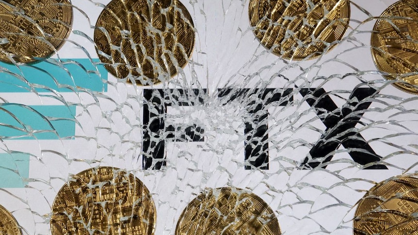 An FTX logo and a representation of cryptocurrencies are seen through broken glass
