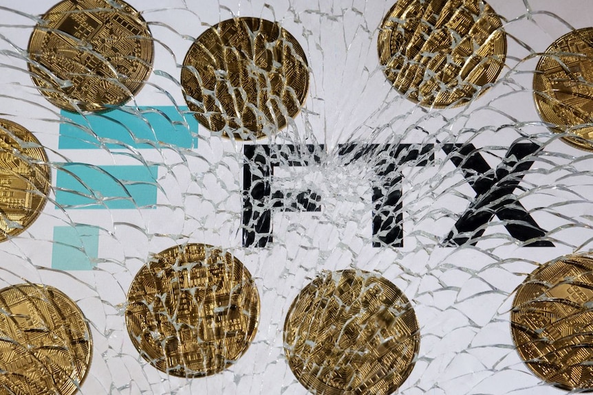 An FTX logo and a representation of cryptocurrencies are seen through broken glass