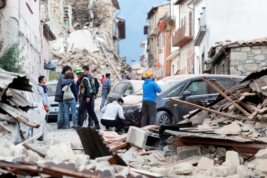 People stand among rubble after an earthquake in Amatrice, Italy.