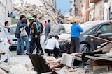 People stand among rubble after an earthquake in Amatrice, Italy.