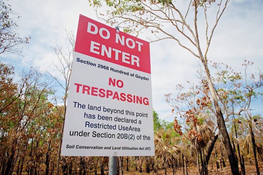 A red and white sign reads 'do not enter'. It is in a rural setting surrounded by trees.