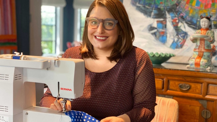 Olivia Crowley sews medical scrubs on a sewing machine.