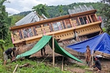 Residents build tents outside their house badly damaged by earthquake in Mamuju, West Sulawesi, Indonesia.