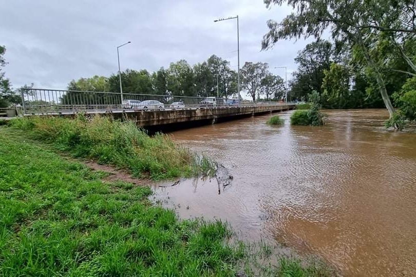 A flooded river with a bridge going over