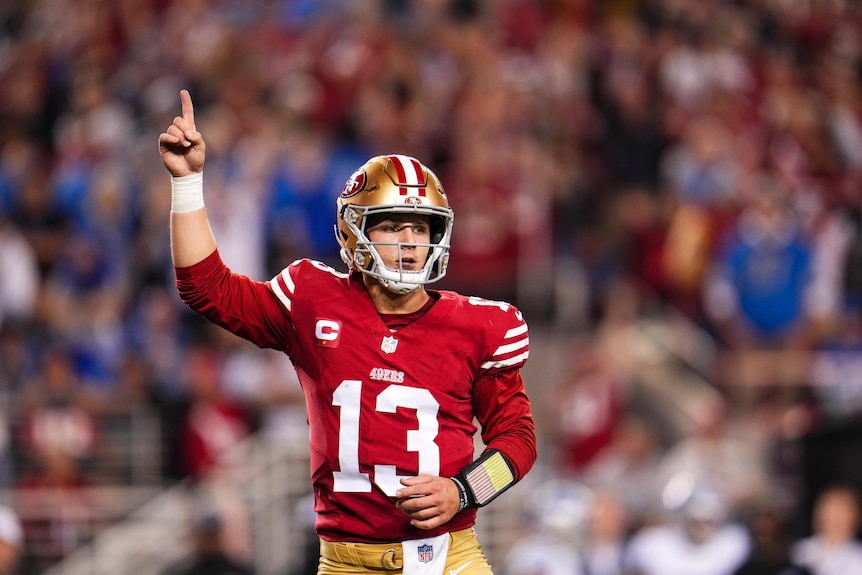 San Francisco 49ers quarterback Brock Purdy points to the sky during an NFL game.