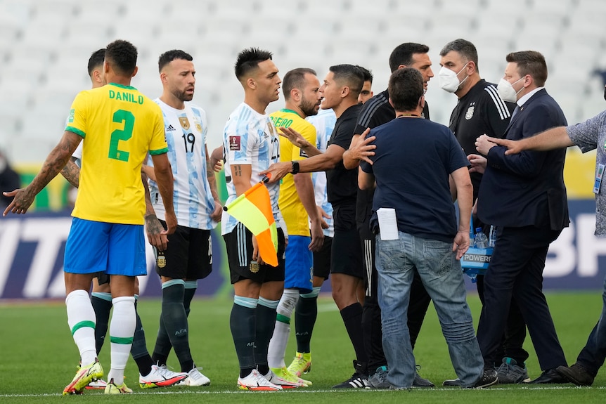 Jogador de futebol e oficiais discutem 