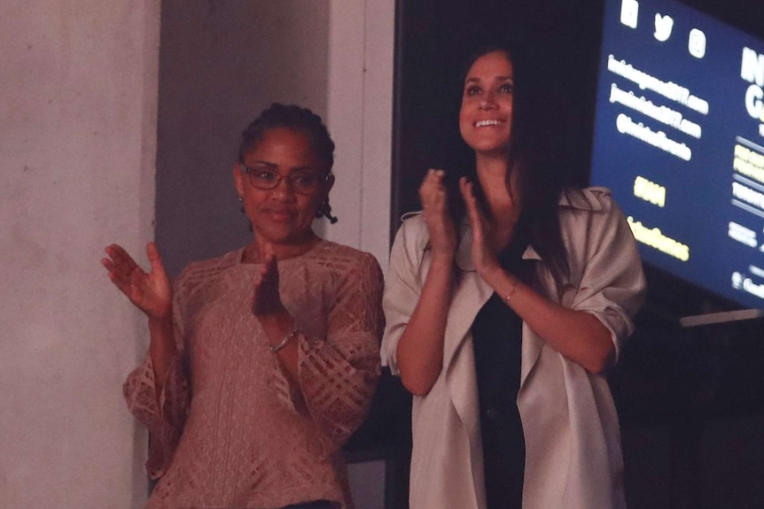 Meghan Markle and her mother Doria Ragland are clapping while standing