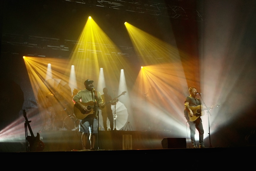 Busby Marou perform on a stage with guitars