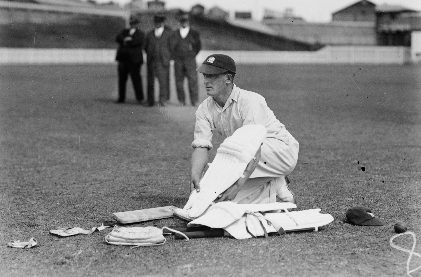 O jogador de críquete inglês Harold Larwood remove as almofadas.