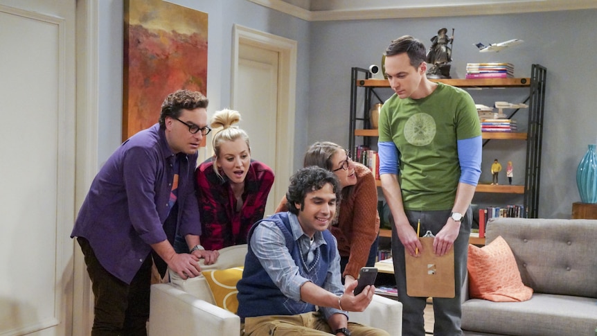 A scene from Big Bang Theory with the characters looking at a phone