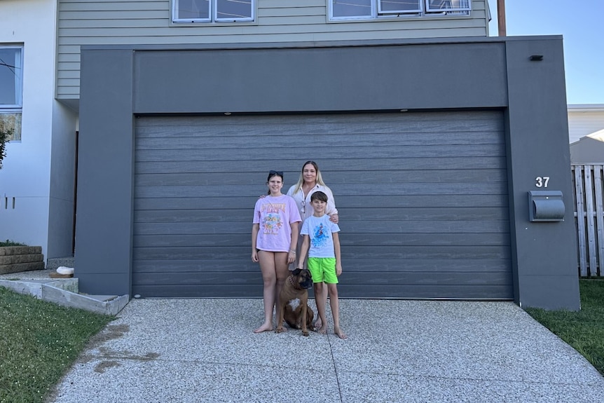 mum and her two kids and dog out the front of her house