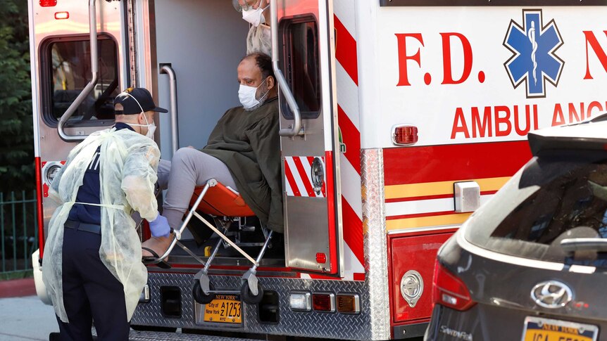 A man in a face mask is lifted into a New York ambulance