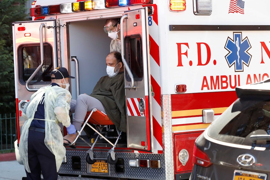 A man in a face mask is lifted into a New York ambulance