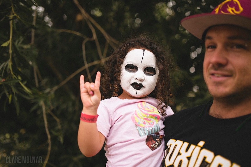 A small child in black and white face paint