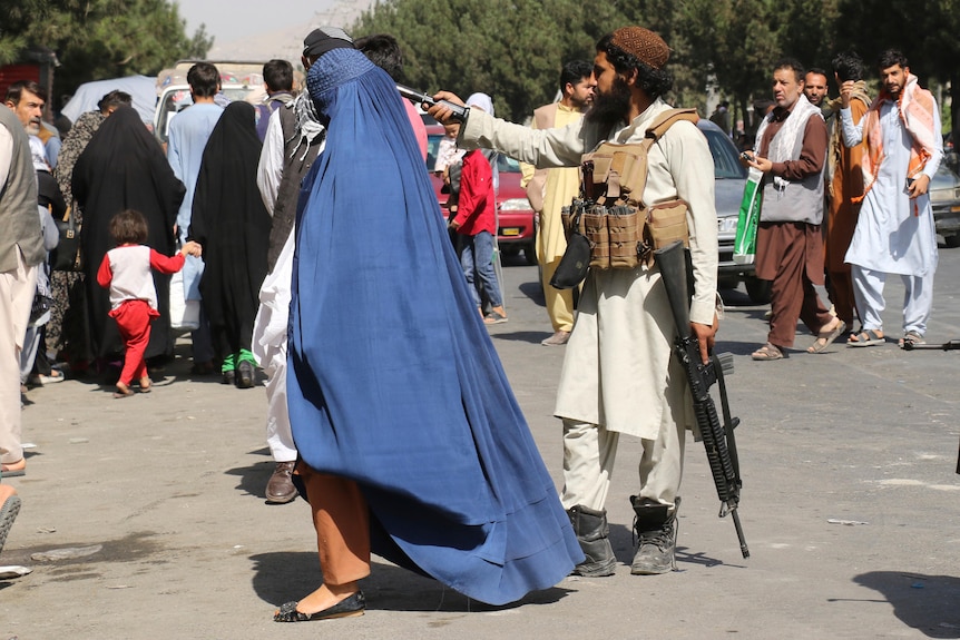 Taliban fighters stand guard outside the airport after Thursday's deadly attacks