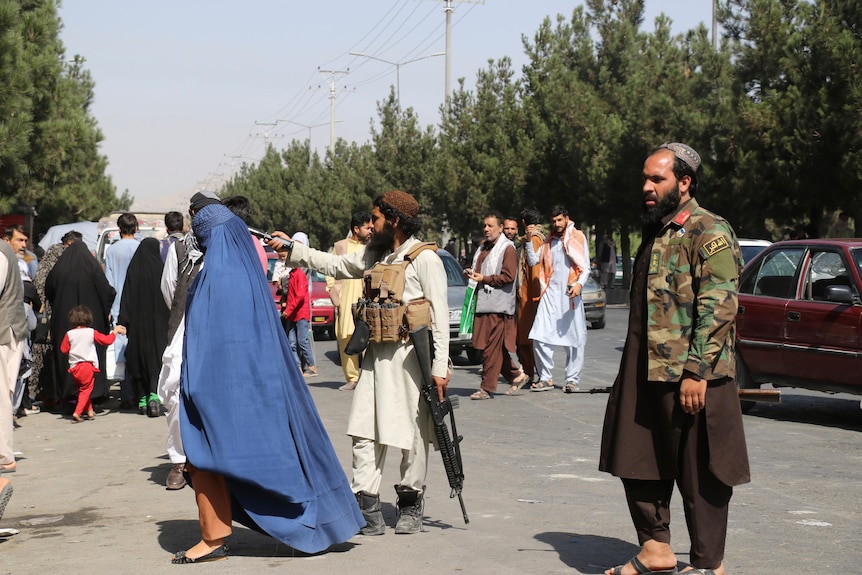 Taliban fighters stand guard outside the airport after Thursday's deadly attacks