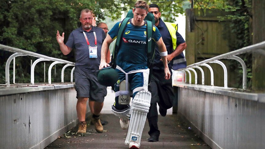 A cricketers carries his kit after practice.