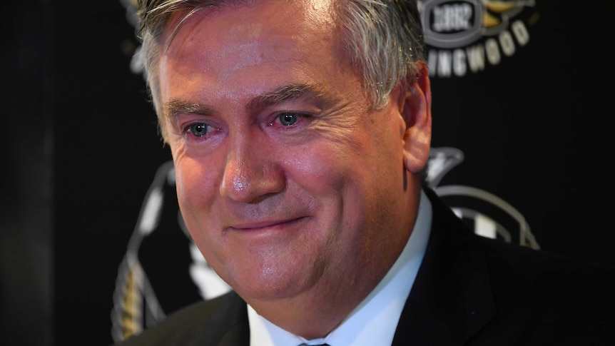 Eddie McGuire has red, teary eyes as he smirks during a press conference